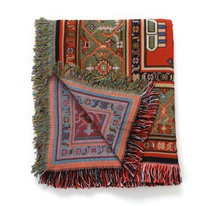 Détail de couverture de camping bohème tissée avec motifs géométriques colorés et franges