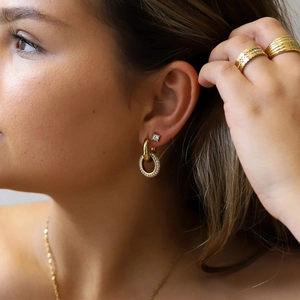 Detail shot of 18K gold plated stainless steel chunky hoops with zircon pendant on a model
