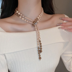 Detail of double-layer pearl necklace with sparkling diamond-set clasp and long tassel