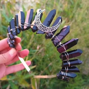 Detailed view of handmade Wicca crown with dark crystals and silver crescent moon charm