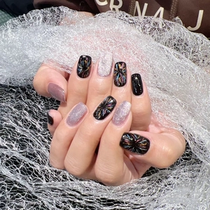 Dark cat-eye press-on nails with colorful fireworks patterns and purple glitter