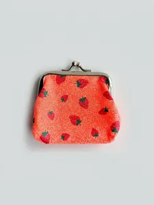Macro detail of red strawberry print coin purse with silver metal ball clasp closure