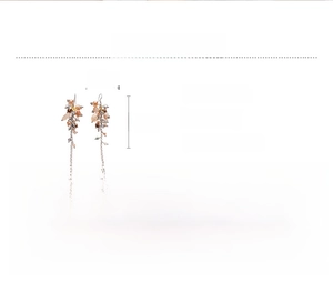 Detail view of long glass beaded fringe earrings in pink and champagne tones