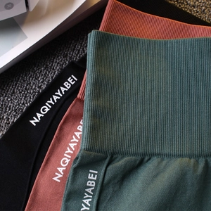 Détail de short de yoga sans couture à taille haute, ceinture côtelée et logo en trois couleurs