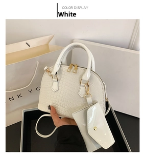 Detailed macro view of white crocodile pattern shell bag with golden metal hardware