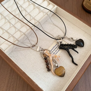 Detail of vintage heart and coral branch pendants on dual-layer beaded chain necklaces