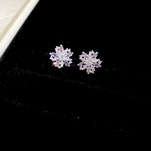 Detail view of purple snowflake flower studs with zircon in black jewelry box