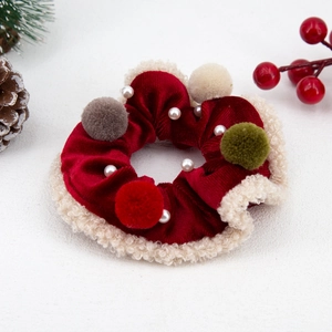 Detail of red velvet Christmas scrunchie with beige fur trim and colorful plush balls