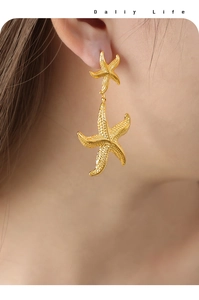 Gros plan de boucles d'oreilles pendantes double étoile de mer dorées sur un mannequin