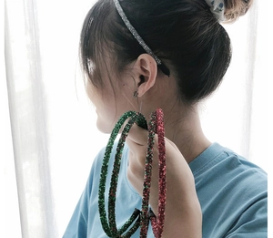 Close-up of glitter headbands in silver, green and red colors on a female model