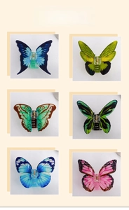 Detail view of butterfly hair claws in six gradient colors with bionic wing patterns
