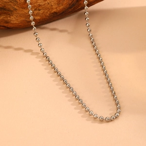 Close-up of classic silver stainless steel bead chain necklace on a rustic wood background