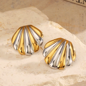 Elegant gold and silver tone shell stud earrings displayed on a natural textured stone