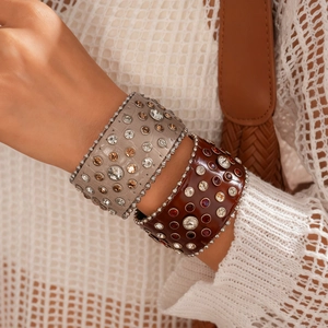 Gros plan de bracelets manchettes en cuir bohème avec strass colorés et rivets argentés
