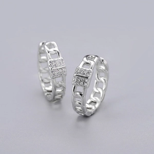 Macro detail of silver chain-link ring featuring a rectangular micro-set zircon panel