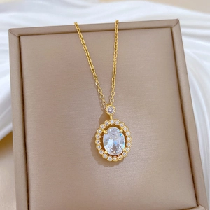 Detailed macro shot of oval-cut zircon pendant with halo diamonds on gold steel chain