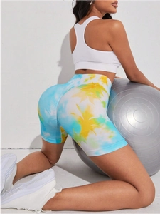 Dettaglio dei pantaloncini fitness tie-dye blu e gialli a vita alta con arricciatura push-up