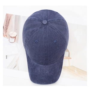 Top view of a washed navy cotton baseball cap with ventilation eyelets and retro texture