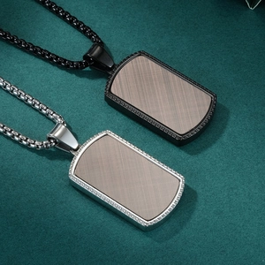 Men's stainless steel military tag necklaces in black and silver on textured background