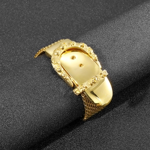 Detail of gold snake bone mesh bracelet with skull embossed buckle on black texture