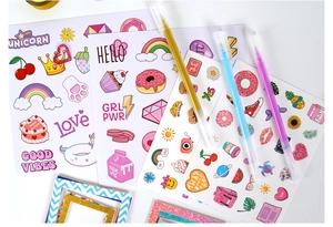 Detailed flat lay of cartoon DIY journal stickers with colorful pens and unicorn designs
