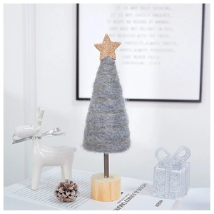 Close-up of handmade grey felt Christmas tree with gold star on a wooden base