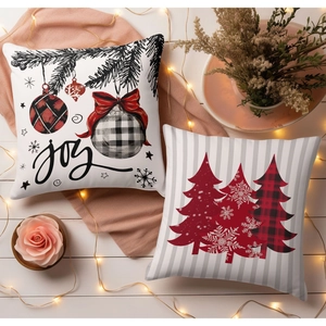Christmas pillow covers with Joy text and reindeer tree design on a warm lit background