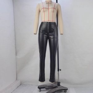Detail of high-waist black PU leather trousers featuring a front metal zipper and slim seams