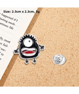 Detail view showing a 2.5cm cartoon monster enamel pin with silver butterfly clutch back