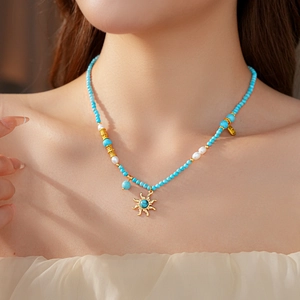 Vue détaillée du collier pendentif soleil avec perles turquoise et petites perles