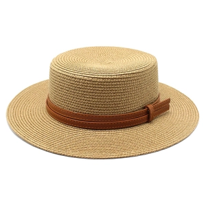 Detail of natural woven straw boater hat featuring a brown leather decorative band