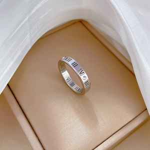 Detail of silver titanium ring featuring Roman numeral cut-outs and small crystals