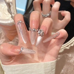 Macro shot of luxury almond cat eye fake nails with crystal flower and metal chains