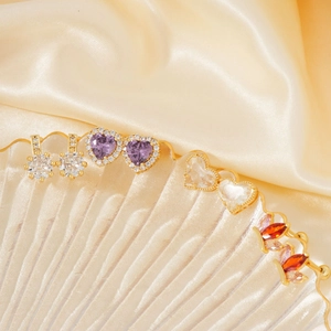 Exquisite gold-plated copper stud earrings with zircon crystals on premium silk background
