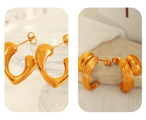 Detailed view of gold heart stud and ribbed C-shaped earrings with polished finish