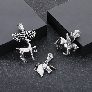 Detail of silver unicorn, flying horse, and deer pendants in polished stainless steel