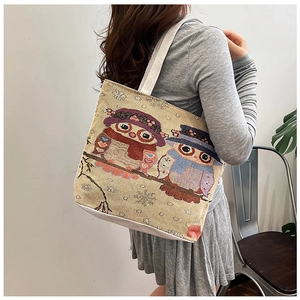 Canvas tote bag with owl embroidery carried by model for daily shopping use