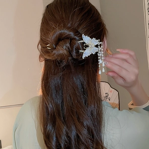 Detailansicht der Schmetterlings-Haarnadel mit Perlenquasten auf eleganter Frisur