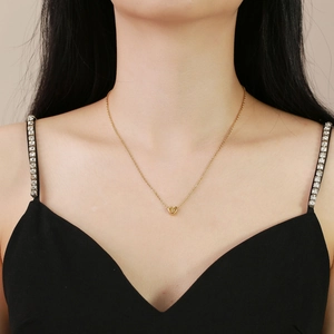 Close-up of golden heart pendant featuring engraved letter D on a delicate necklace chain