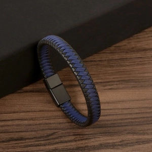 Detail of blue and black braided leather bracelet with black magnetic clasp on gift box