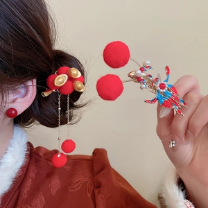 Close-up of New Chinese style hair clip with golden ingot and red pom-pom tassel