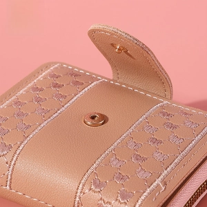 Close-up of heart-pattern embroidery and premium leather texture on pink wallet