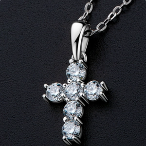 Macro view of a silver cross pendant featuring six round-cut moissanite stones in claw setting