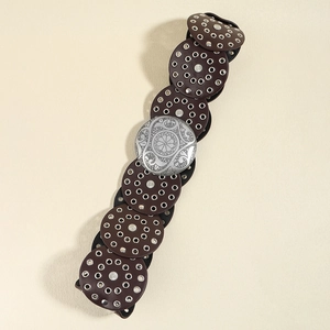 Detail of vintage leather belt with silver star studs and ornate floral buckle