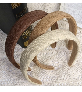 Detailed close-up of woven cotton linen headbands in three natural earth tones