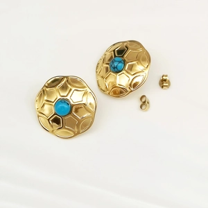 Macro shot of vintage gold butterfly earrings with blue turquoise center stones