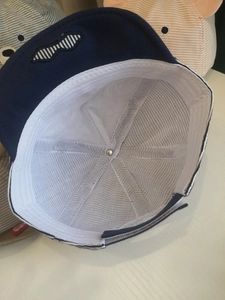 Detail of infant cap with breathable white mesh lining and adjustable velcro strap