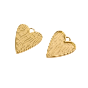 Macro shot of two golden heart pendants with textured finish and small link loops