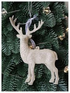 Close-up of sparkling champagne reindeer ornament with fine glitter on a green tree