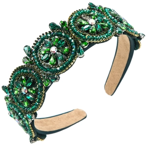 Macro detail of vintage emerald green crystal headband with golden floral beadwork
